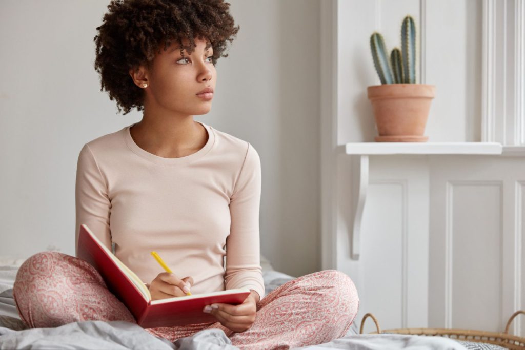 A woman reflecting on life as she reads in bed.