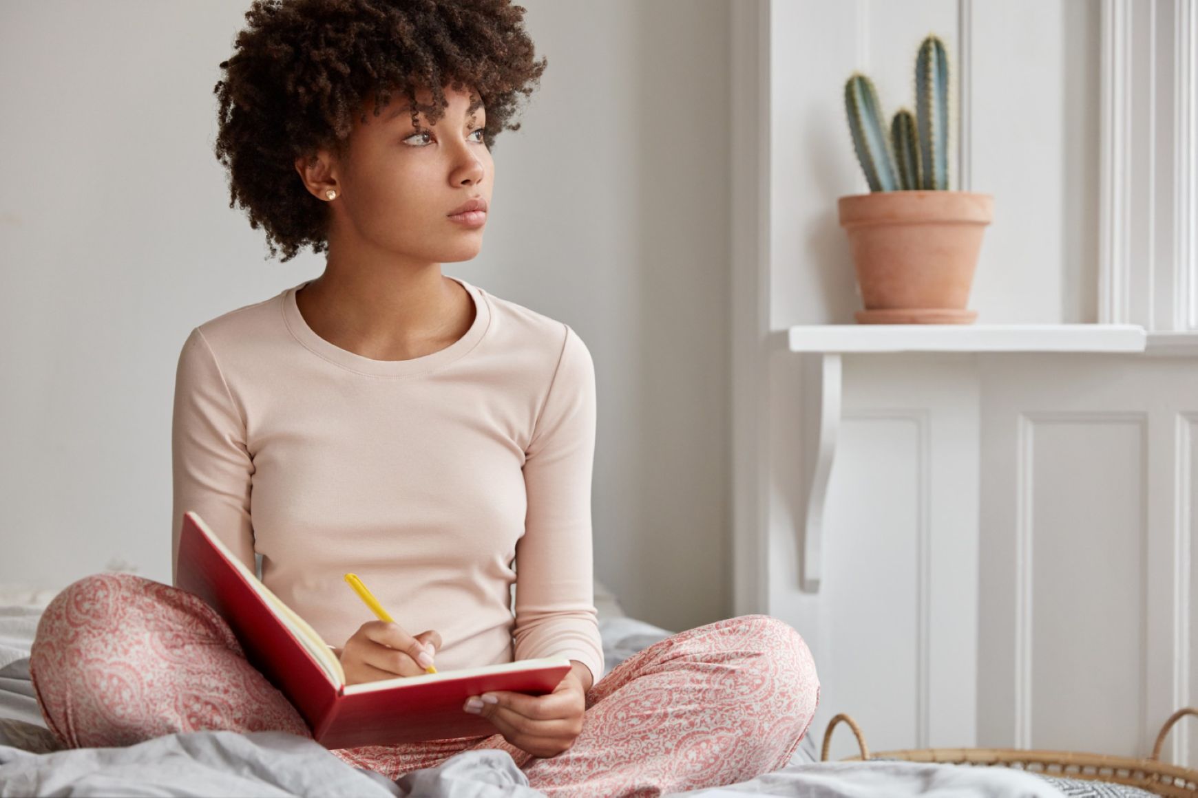 A woman reflecting on life as she reads in bed.
