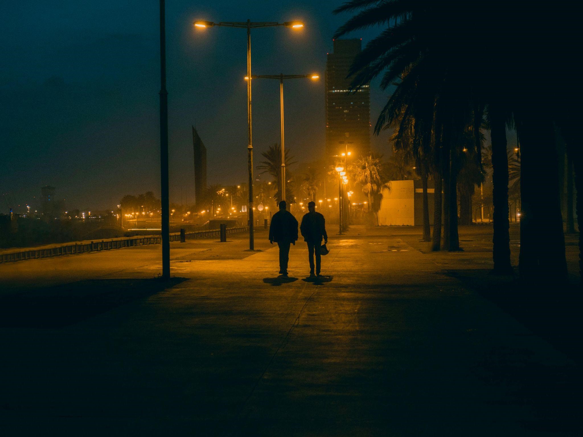 Two people walk on a dimly lit path, conveying how meaningful coincidences change your direction.