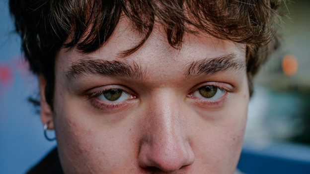 Close-up of a young person looking and observing intensely.