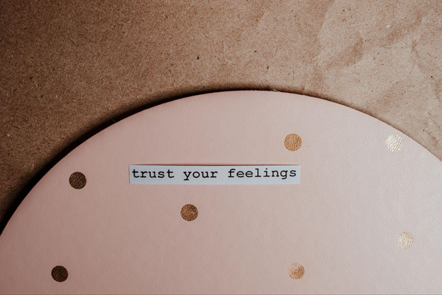 A text "trust your feelings" set against a brown background, conveying positivity and intuition.